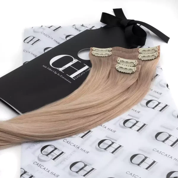Cascata Hair Extensions - Blonde Full Set - Image of blonde hair extensions sitting on Cascata branded wrapping paper