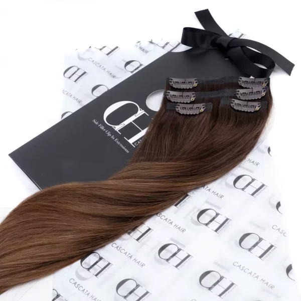 Cascata Hair Extensions - Cookie Crumble Full Set - Image of brunette hair extensions sitting on Cascata branded wrapping paper