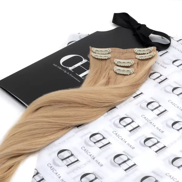 Cascata Hair Extensions - Custard Blonde Full Set - Image of blonde hair extensions sitting on Cascata branded wrapping paper